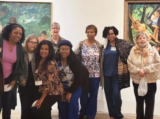 Group of staff and residents posing in an art gallery