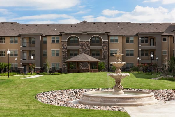 Exterior view of a senior living facility with landscaped garden