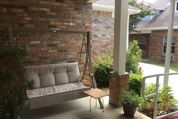 Outdoor seating area with swing and plants