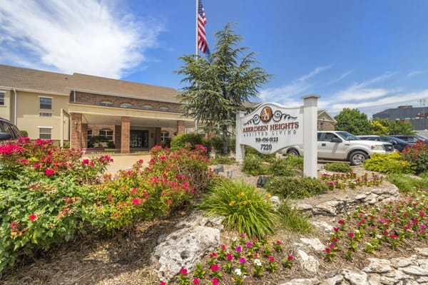 Exterior view of Aberdeen Heights Assisted Living with flowers and signage