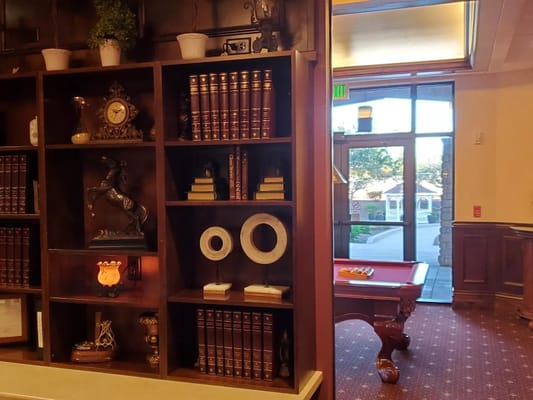 Interior view of a common area with bookshelves and pool table