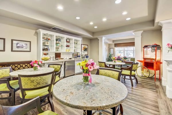 Bright dining area with round tables and flowers