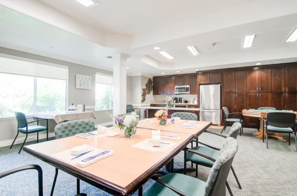 Dining area set up for residents with flowers and utensils