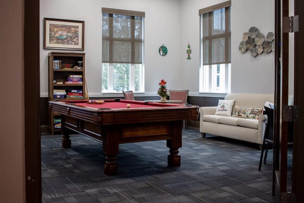 Bright game room with a pool table and comfortable seating