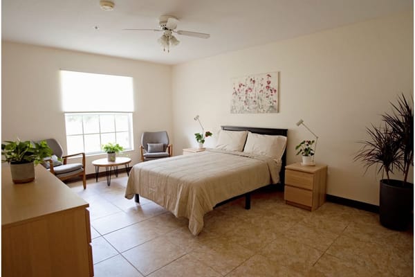 A well-furnished private room with plants and natural light