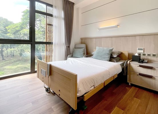 Well-furnished nursing home room with large window