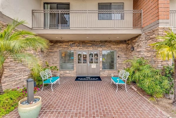 Exterior entrance of a senior living facility with plants
