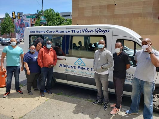 Staff members posing next to a facility transport van