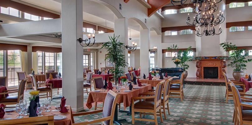 Spacious dining room with tables set for meals and large windows