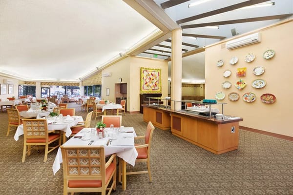 Spacious dining area with white tablecloths and decorative plates