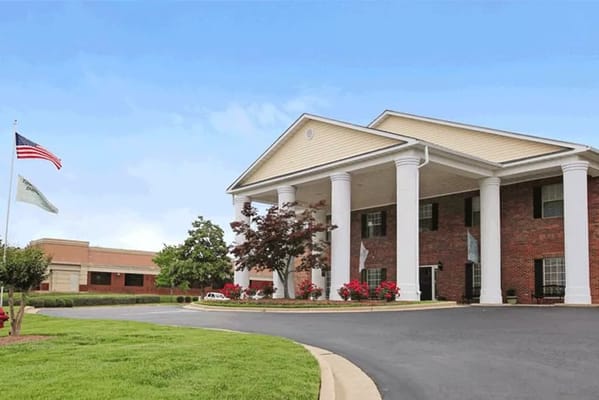 Exterior view of a senior living facility with gardens