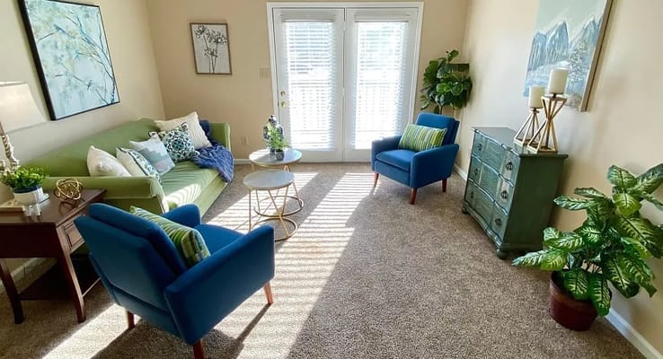 Bright living room with green sofa and blue chairs