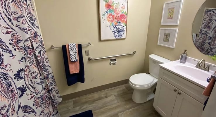 Modern bathroom with a sink, toilet, and decorative wall art.