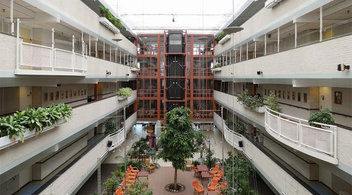 Interior view of a bright atrium with plants and seating