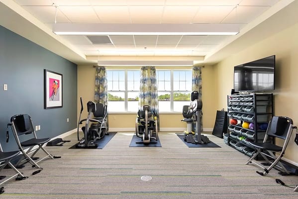 Well-equipped fitness room with exercise machines and seating