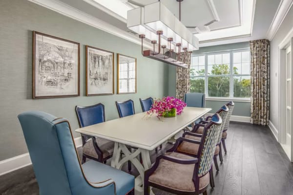 Bright dining room with a large table and colorful chairs