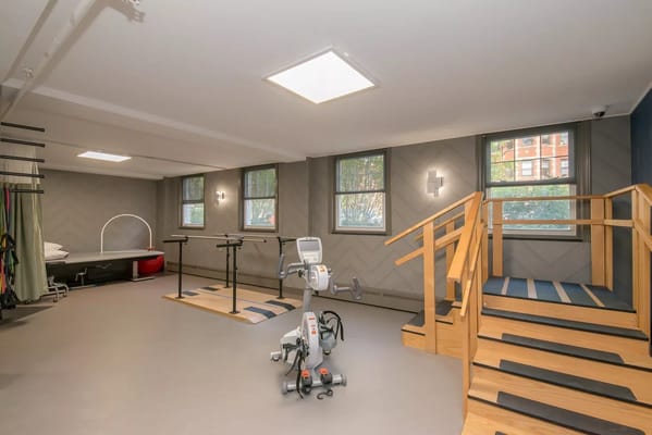 Bright fitness area with exercise equipment and windows
