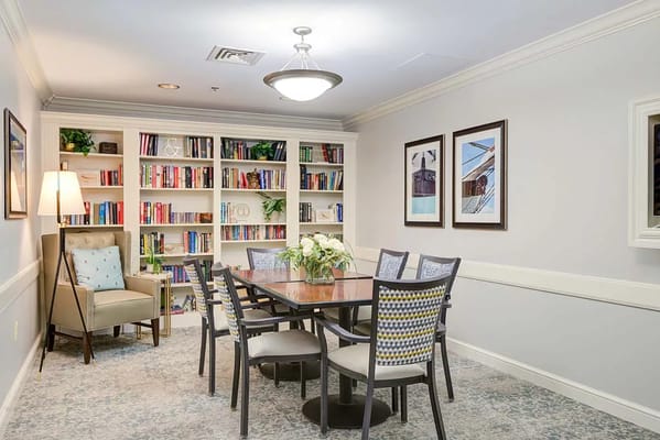Bright common area with a table and bookshelves