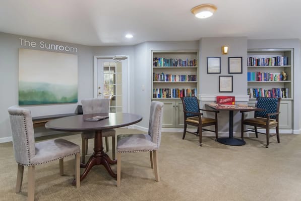 Interior view of a serene sunroom with bookshelves