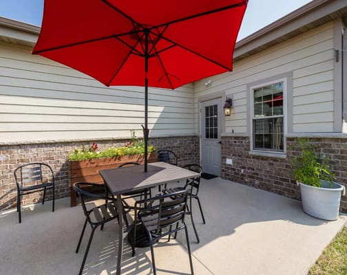 Patio area with a red umbrella and seating