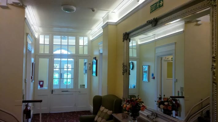 Interior hallway with a mirror and floral arrangement