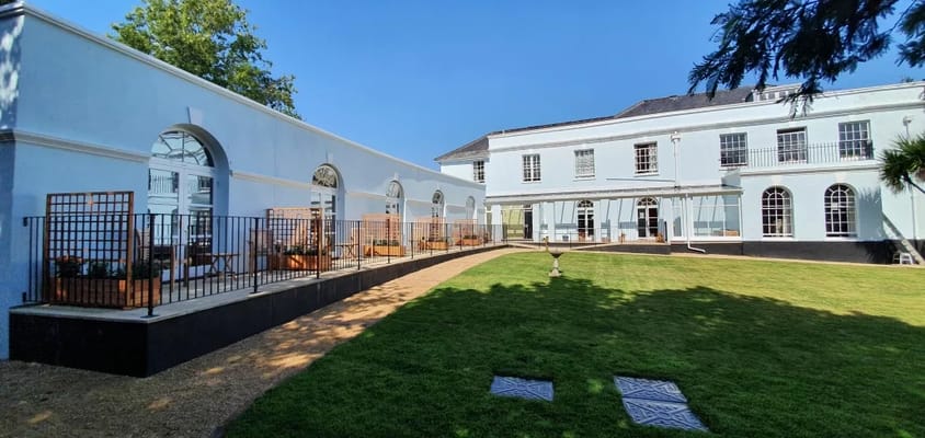 Exterior view of Arcot House Care Home with garden area