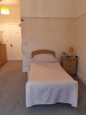 Private room with a single bed and dresser