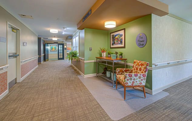 Brightly lit corridor with decorative chair and flower shop sign
