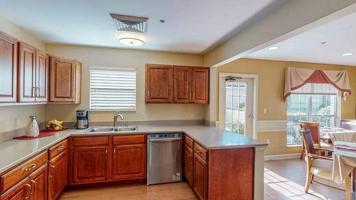Bright kitchen area with wooden cabinets and appliances