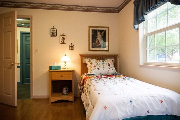 Cozy resident room with floral bedding and natural light