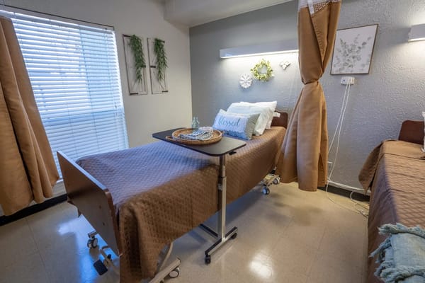 Brightly lit resident room with a hospital bed and decorative elements