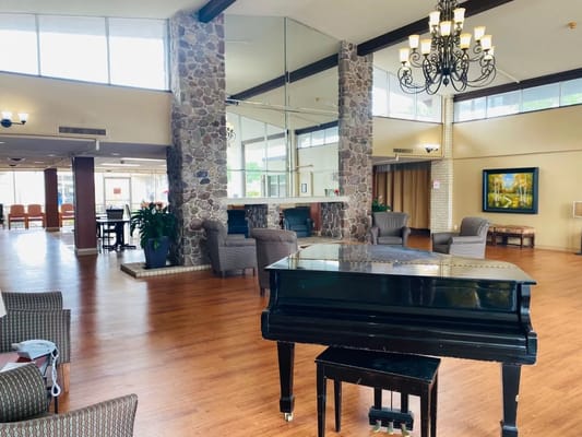 Interior view of a common area with a piano and seating