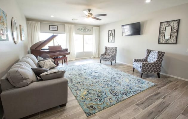 Bright common area with seating and a piano