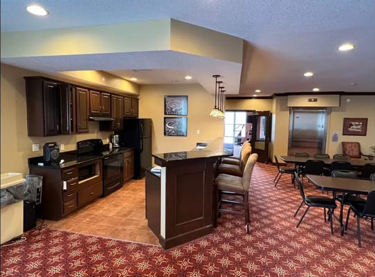 Interior view of a shared social space with kitchenette