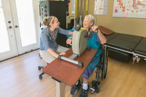 Therapist assisting a resident with exercise equipment