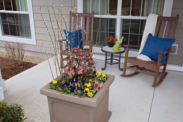 Cozy outdoor seating area with flowers and rocking chairs