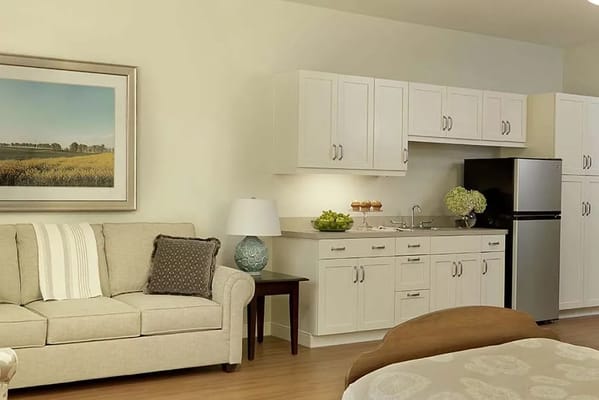 Spacious living room with a couch, kitchenette, and artwork