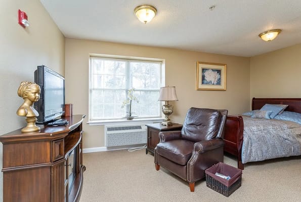 Cozy room with a bed, chair, and television