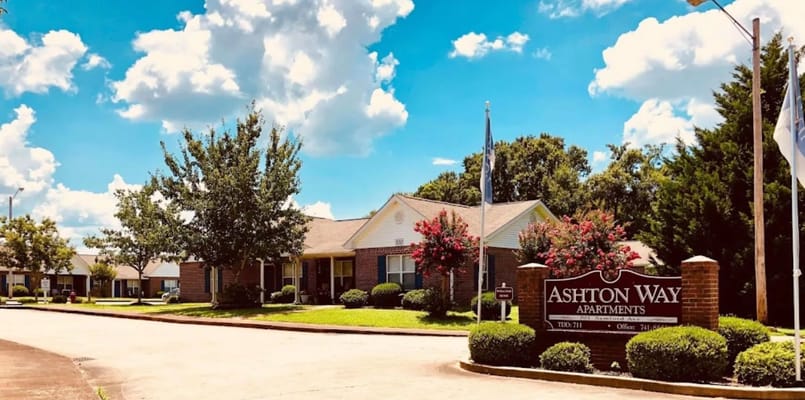 Exterior of Ashton Way Apartments with flowers and trees.
