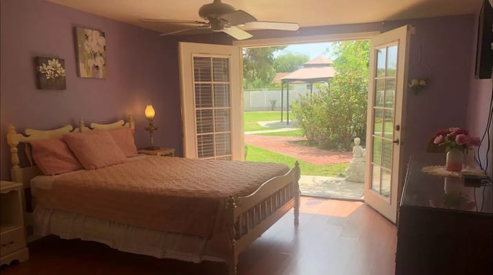 Brightly lit bedroom with patio doors to outdoor space