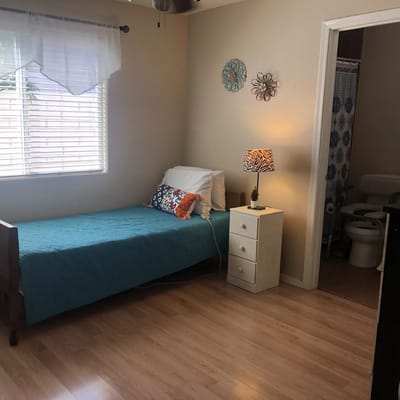 Bright and cozy resident room with a bed and nightstand