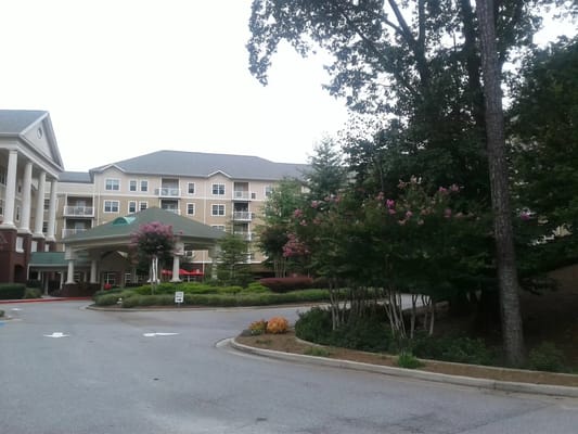 Exterior view of a senior living facility with flowering trees