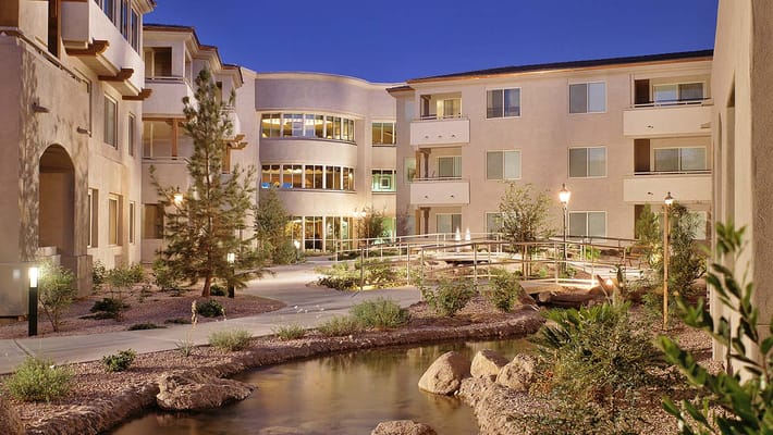 A serene outdoor courtyard with greenery and a stream