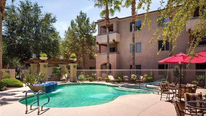 Swimming pool area with lounge chairs and palm trees