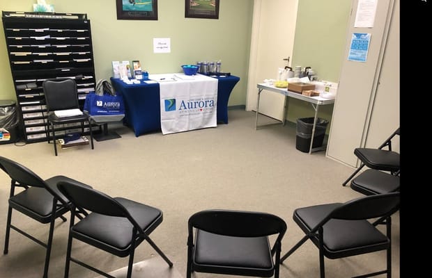 Interior room set up for a gathering with chairs and refreshments