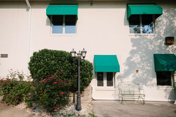 Exterior of Autumn Lake Healthcare featuring green awnings and landscaping.