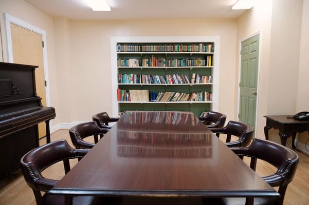 Wooden table and chairs in library with bookshelves