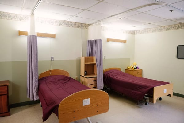 A shared bedroom with two beds and storage furniture.