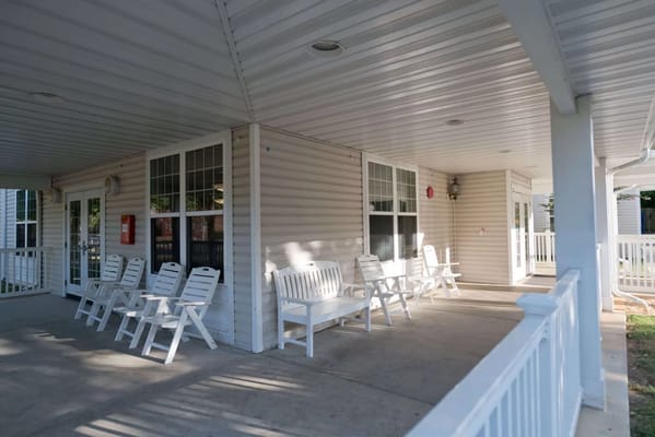 Covered outdoor seating area with white chairs