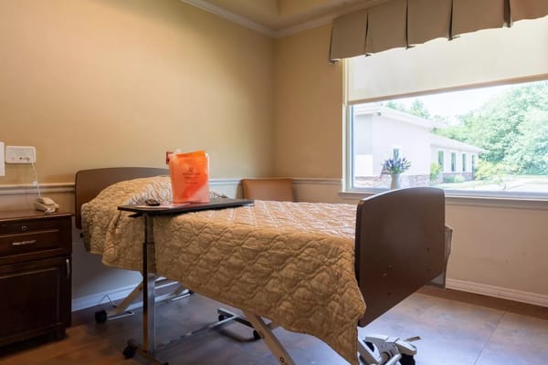 Private resident room with a hospital bed and window